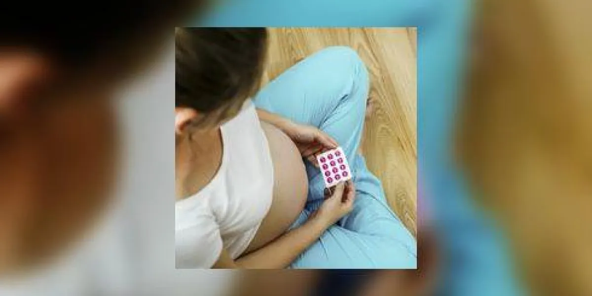 portrait de la femme enceinte méconnaissable tenant des pilules dans ses mains