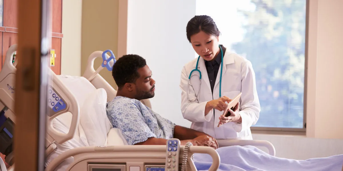 médecin de l'hôpital avec tablette numérique parle à un patient masculin
