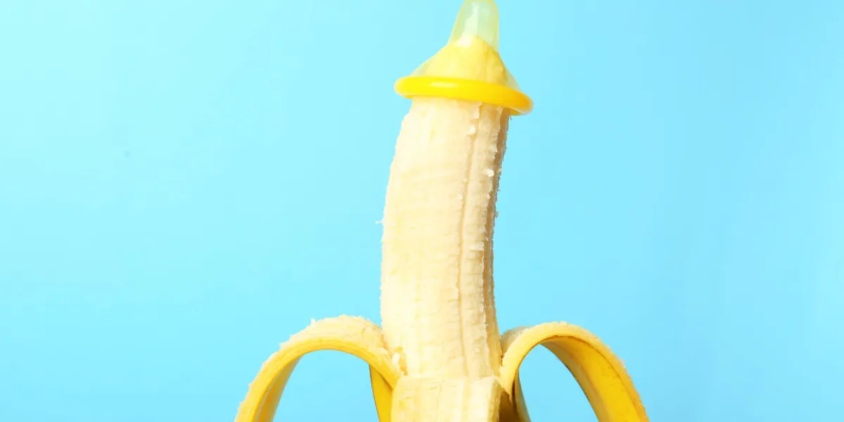 condom on banana against color background safe sex concept condom on banana against color background safe sex concept