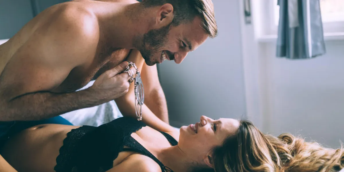 woman and man playing domination games in bed together woman and man playing domination games in bed together