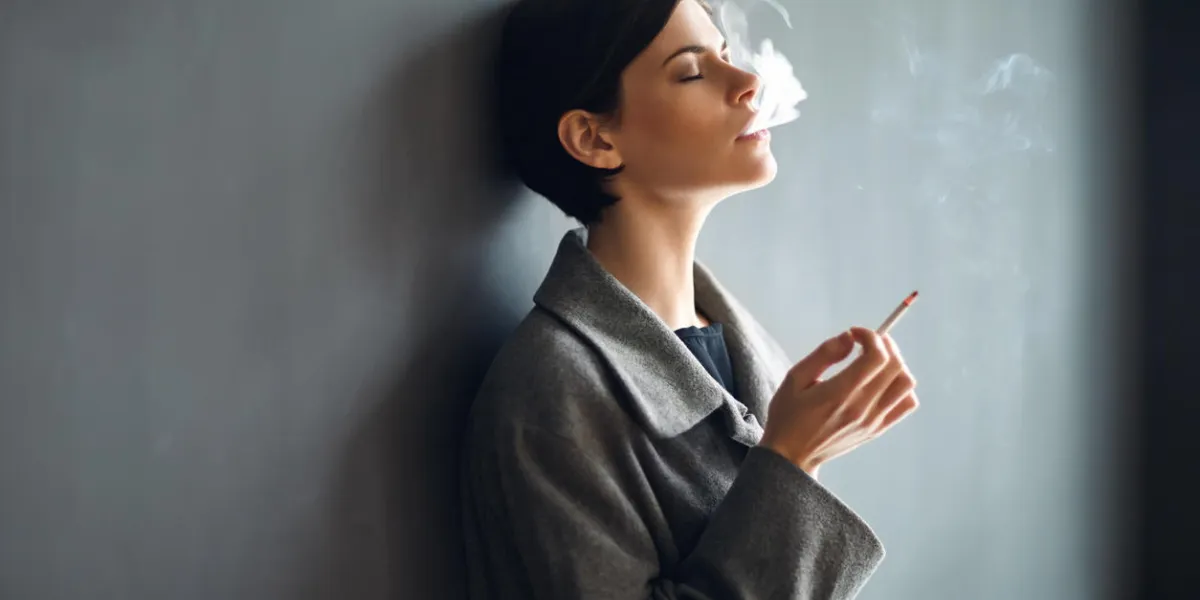 portrait of fashionable woman smoking a cigarette on dark background portrait of fashionable woman smoking a cigarette on dark background