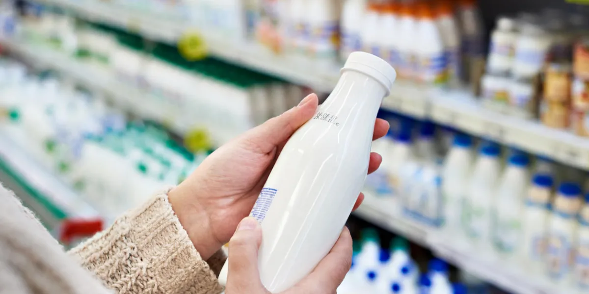 buyer hands with a bottle of milk at the grocery store buyer hands with a bottle of milk at the grocery store
