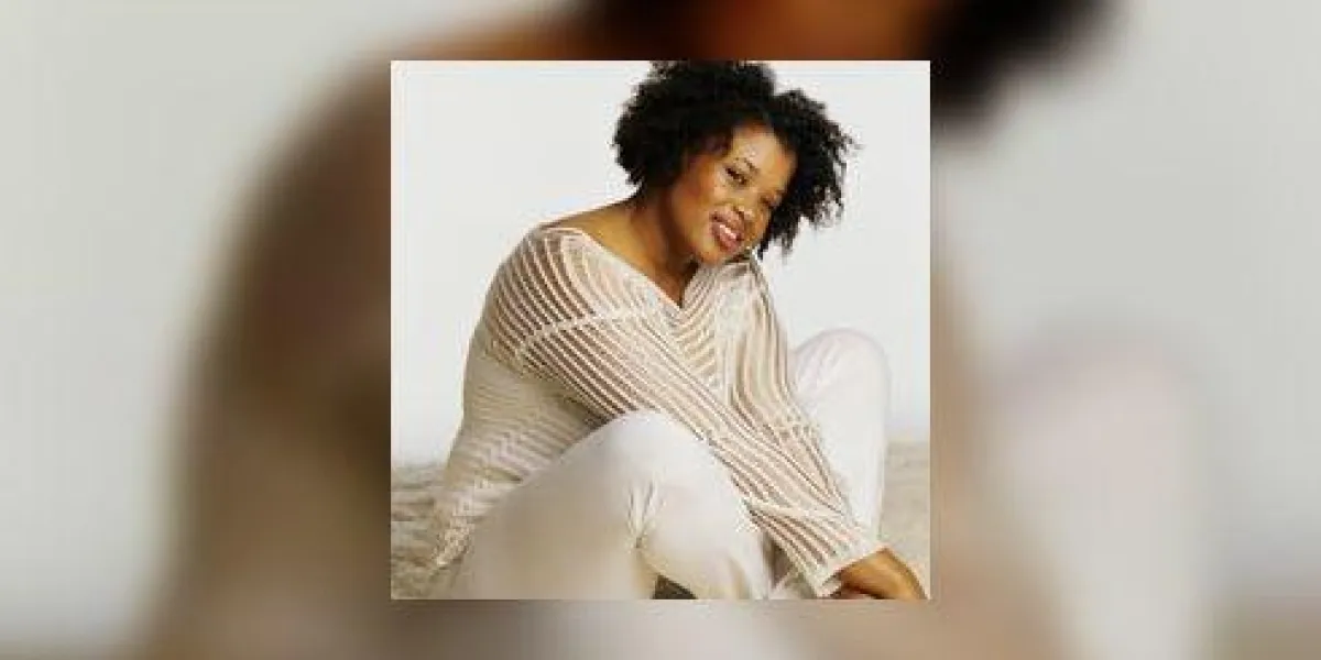 jeune femme assise sur un tapis souriant, portrait