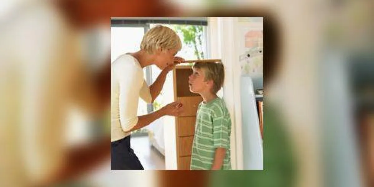 mère mesurant la hauteur du fils (7-9) contre le mur