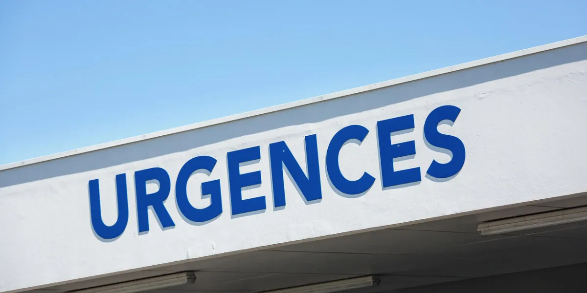 view of closeup of vertical red sign - emergency (urgences in french)
