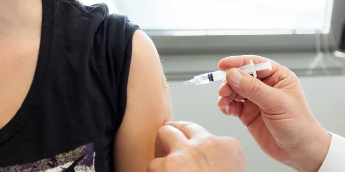 close up of a woman's arm while the vaccine is injected by the doctor