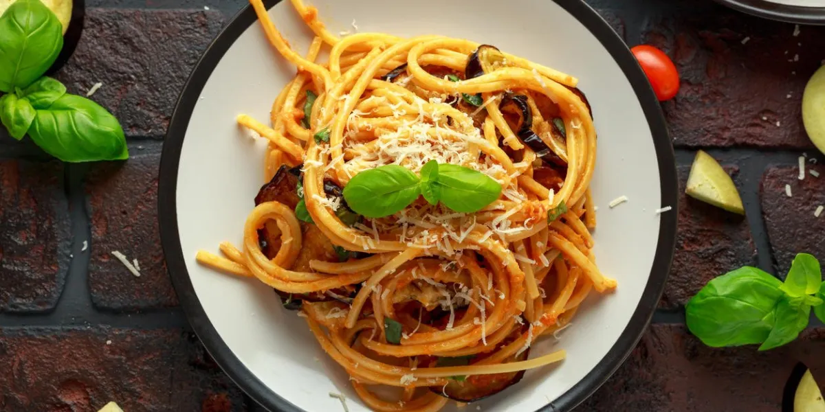 vegetarian italian pasta spaghetti alla norma with eggplant, tomatoes, basil and parmesan cheese vegetarian italian pasta spaghetti alla norma with eggplant, tomatoes, basil and parmesan cheese