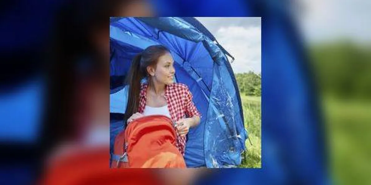 concept de voyage, tourisme, randonnée, camping et personnes - heureuse jeune femme avec sac à dos assis dans la tente concept de voyage, tourisme, randonnée, camping et personnes - heureuse jeune femme avec sac à dos assis dans la tente