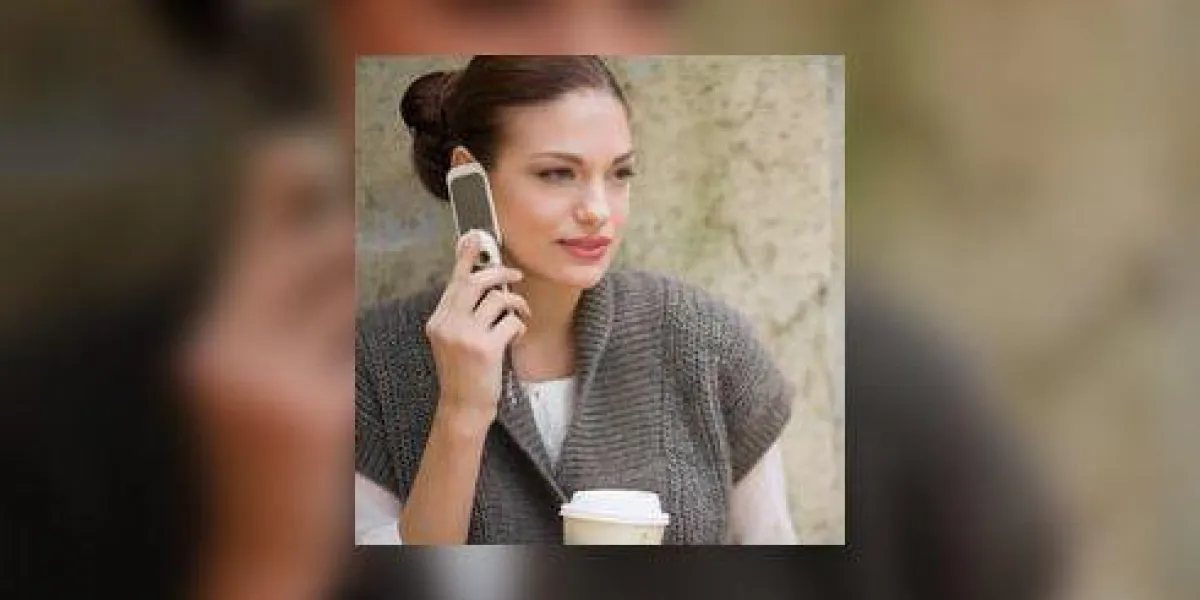 jeune femme, utilisation, téléphone portable, et, tenue, tasse café, contre, mur