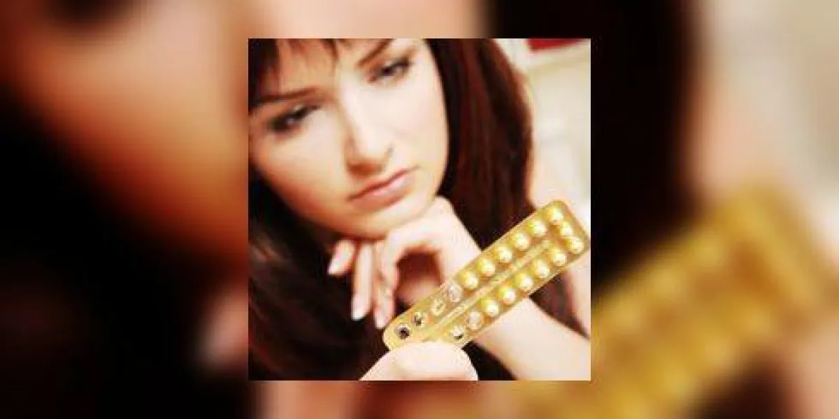 une jolie jeune femme regardant ses pilules contraceptives peu profondes, l'accent est mis sur les pilules