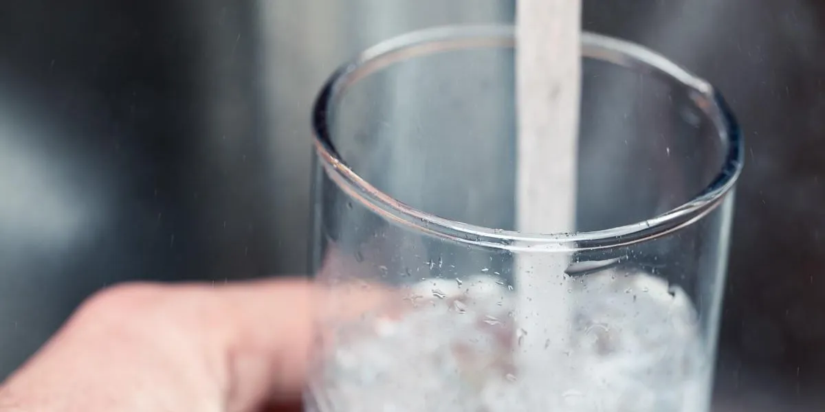 closeup shot of a man pouring a glass of fresh water from a kitchen faucet closeup shot of a man pouring a glass of fresh water from a kitchen faucet