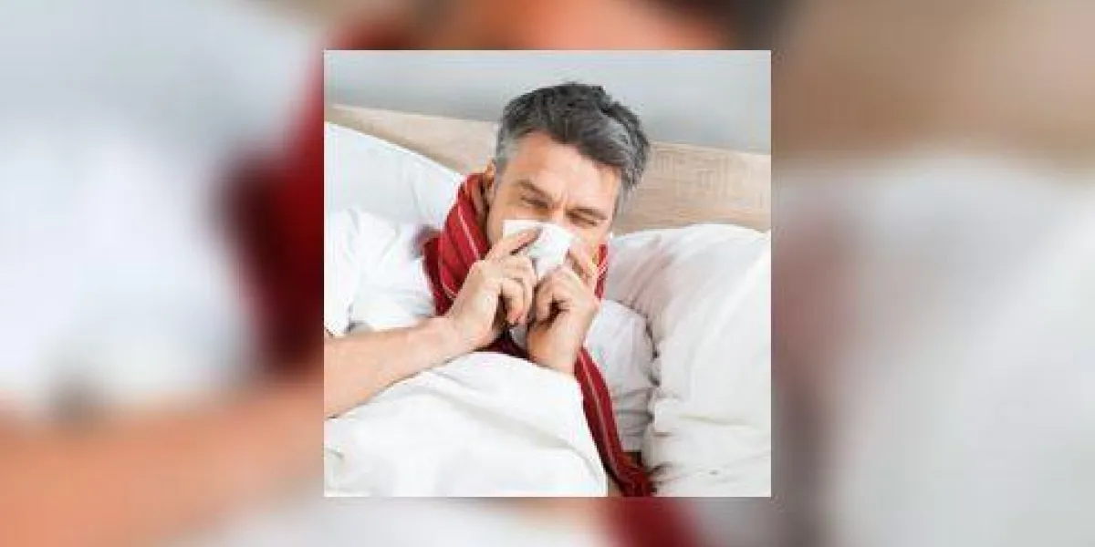 homme d'âge mûr malade soufflant son nez en position couchée sur le lit à la maison