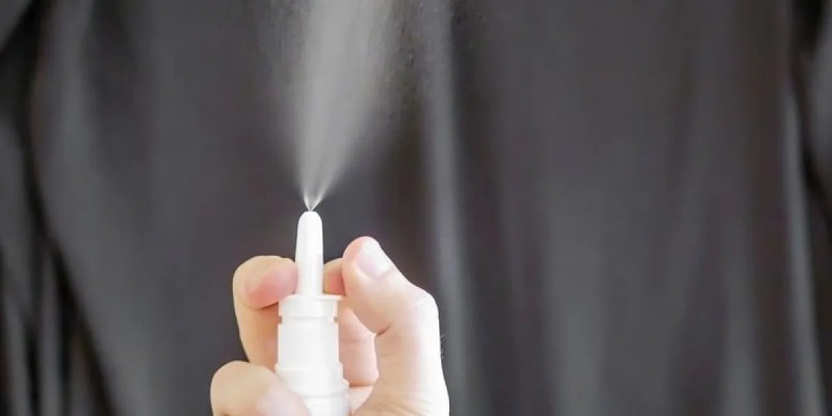 nasal spray in a hand on black background nasal spray in a hand on black background
