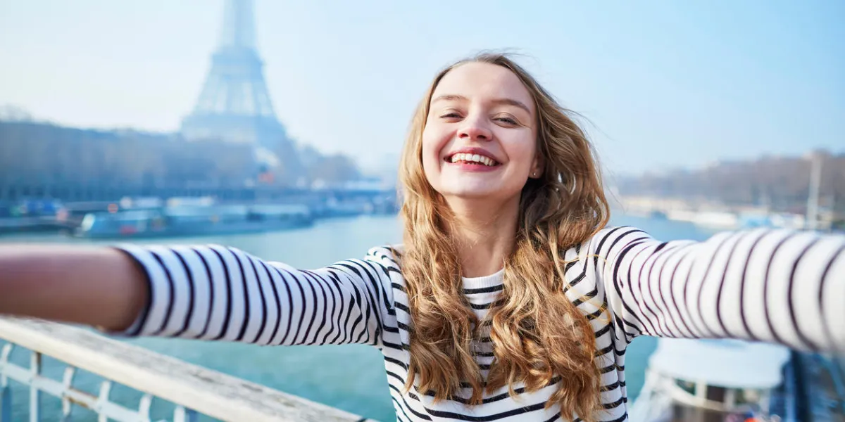 belle jeune fille prenant selfie drôle avec son téléphone portable près de la tour eiffel