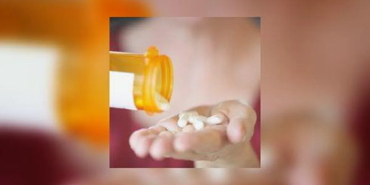 gros plan des mains d'une personne tenant une bouteille de pilules