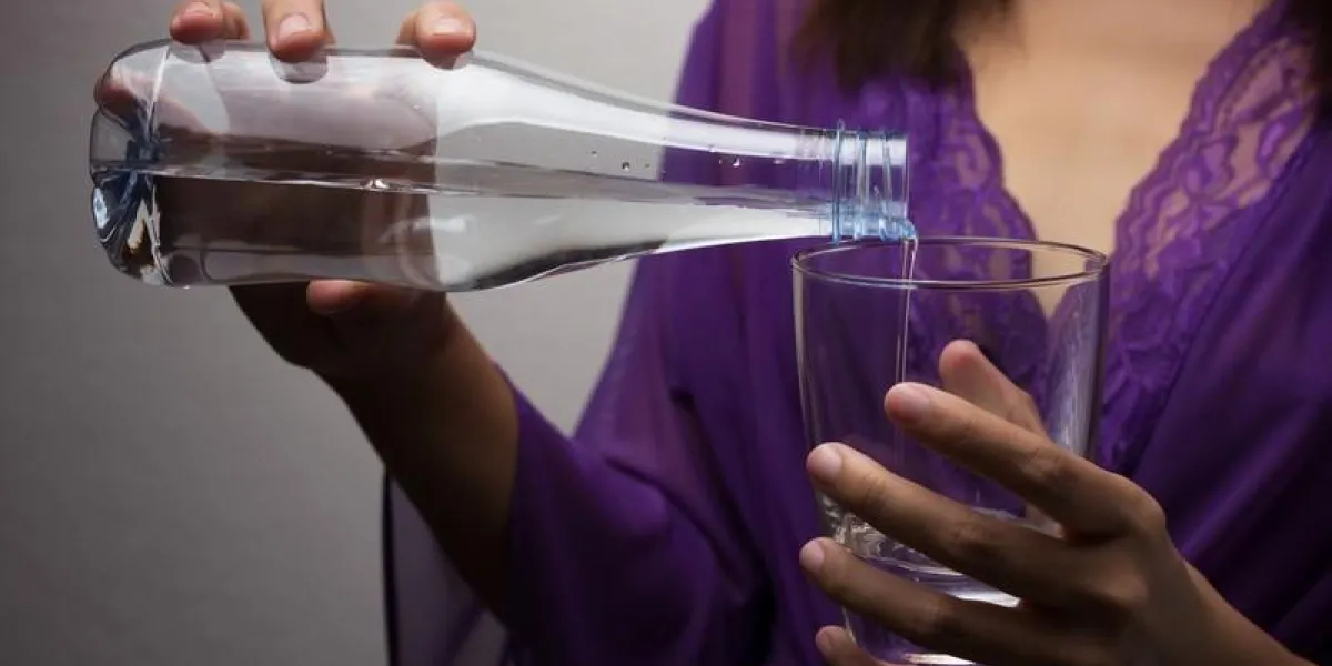 female hands pouring water into a glass female hands pouring water into a glass