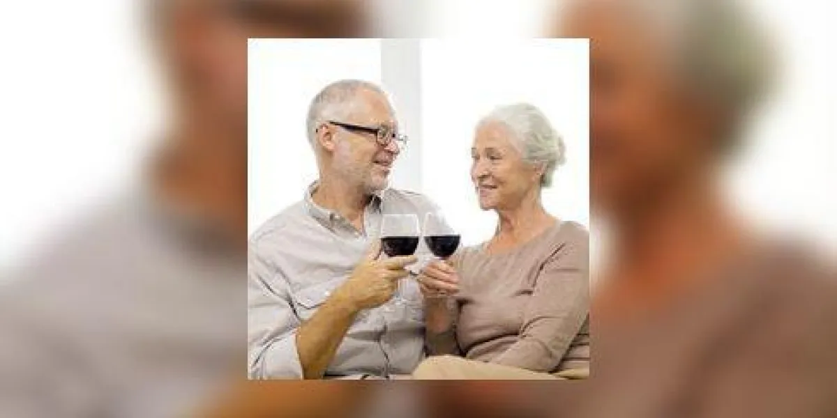 concept de famille, vacances, boissons, âge et personnes - heureux couple de personnes âgées avec des verres de vin rouge à la maison