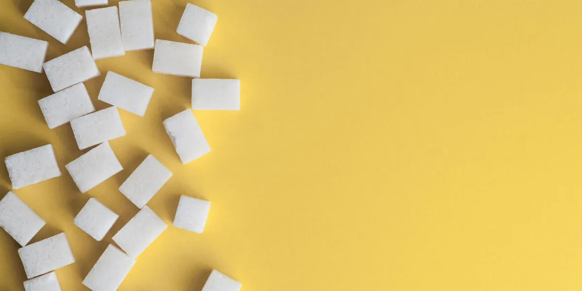 white sugar on yellow background cubes sugar with copy space top view or flat lay white sugar on yellow background cubes sugar with copy space top view or flat lay