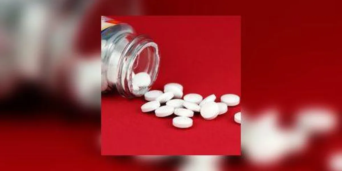 bouteille d'aspirine sur fond rouge