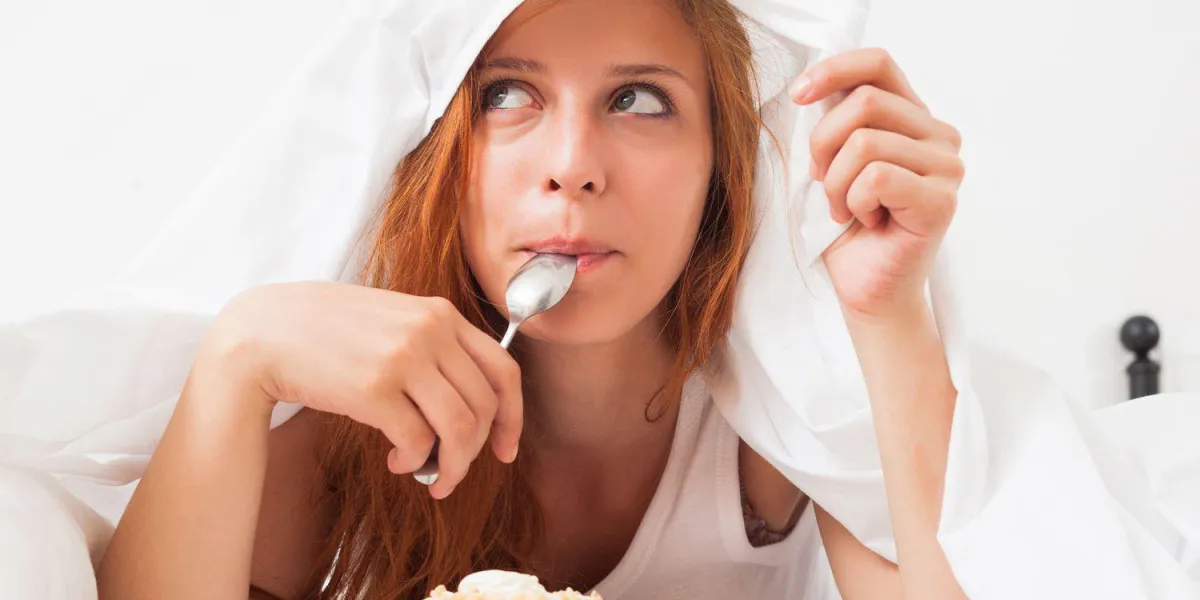 jolie fille mangeant des biscuits dans son lit