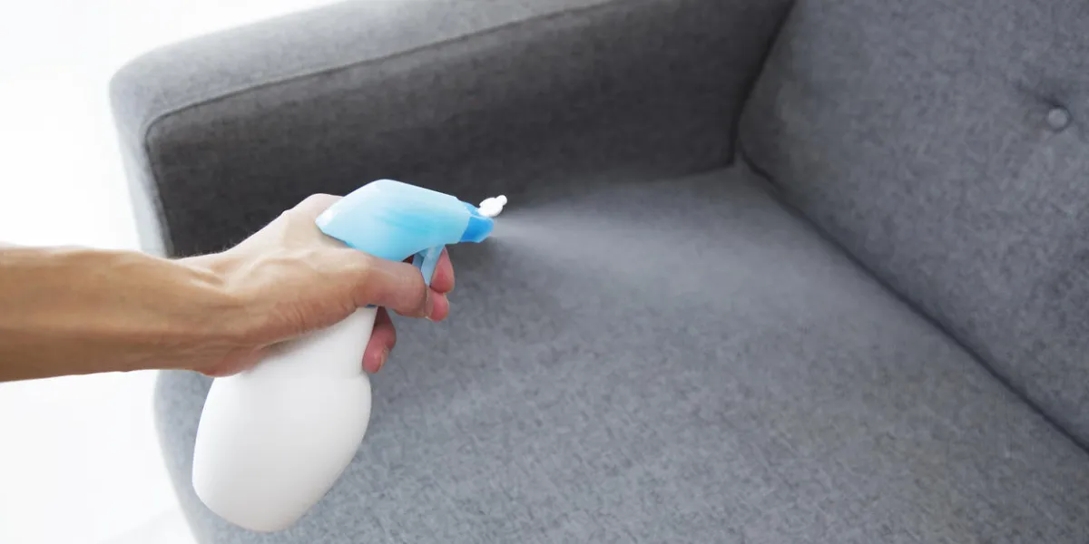 sprayed air freshener in hand on home interior background sprayed air freshener in hand on home interior background
