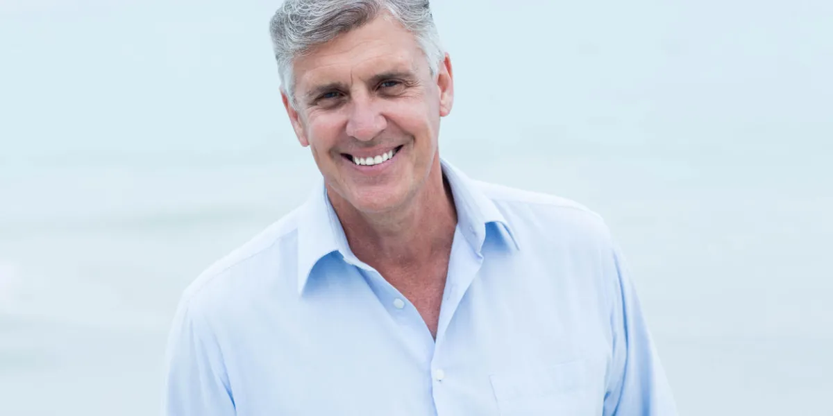 homme souriant, regardant la caméra à la plage homme souriant, regardant la caméra à la plage