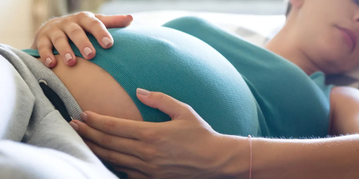 photo de femme enceinte qui dort sur le canapé bleu