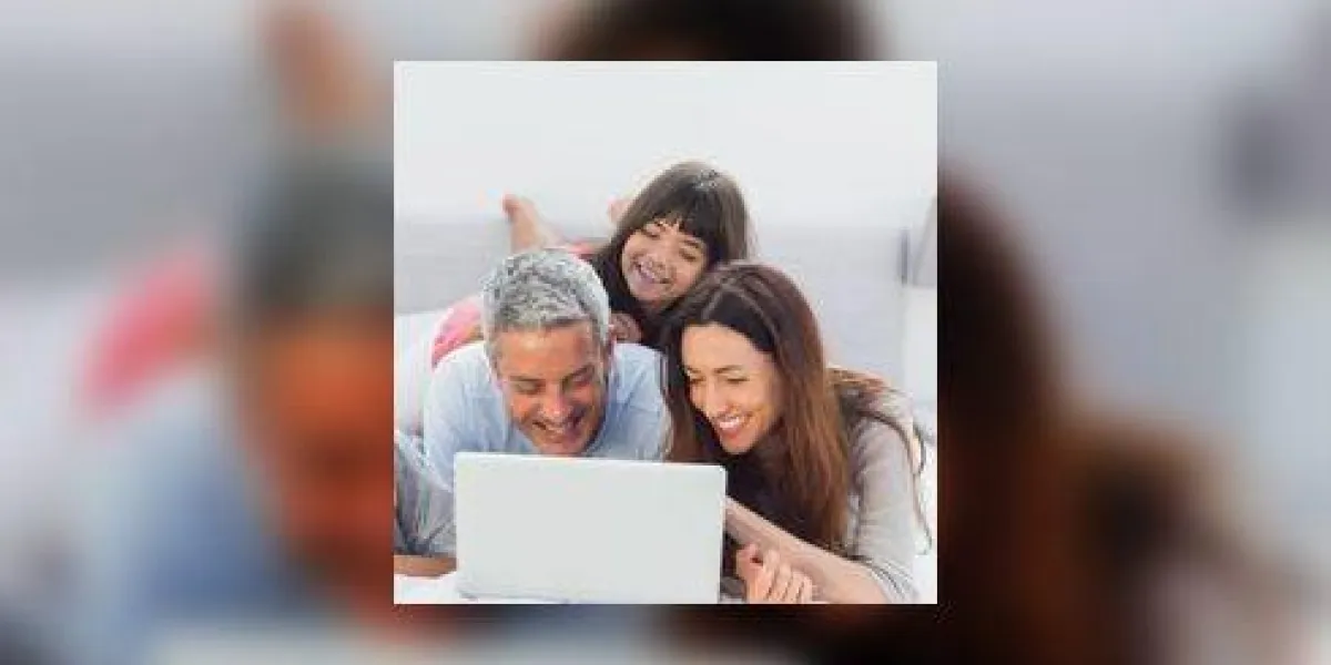 famille allongée sur le lit en utilisant leur ordinateur portable