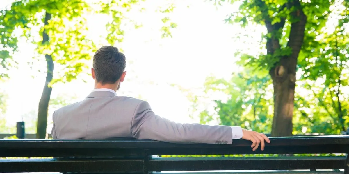 back view portrait of a businessman sitting on the bench outdoors back view portrait of a businessman sitting on the bench outdoors