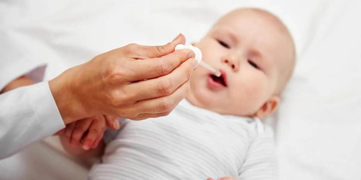 portrait of baby girl getting vaccine drops in clinic health care and therapy concept portrait of baby girl getting vaccine drops in clinic health care and therapy concept
