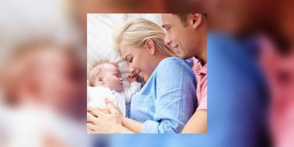 parents couchés avec bébé fille au lit ensemble