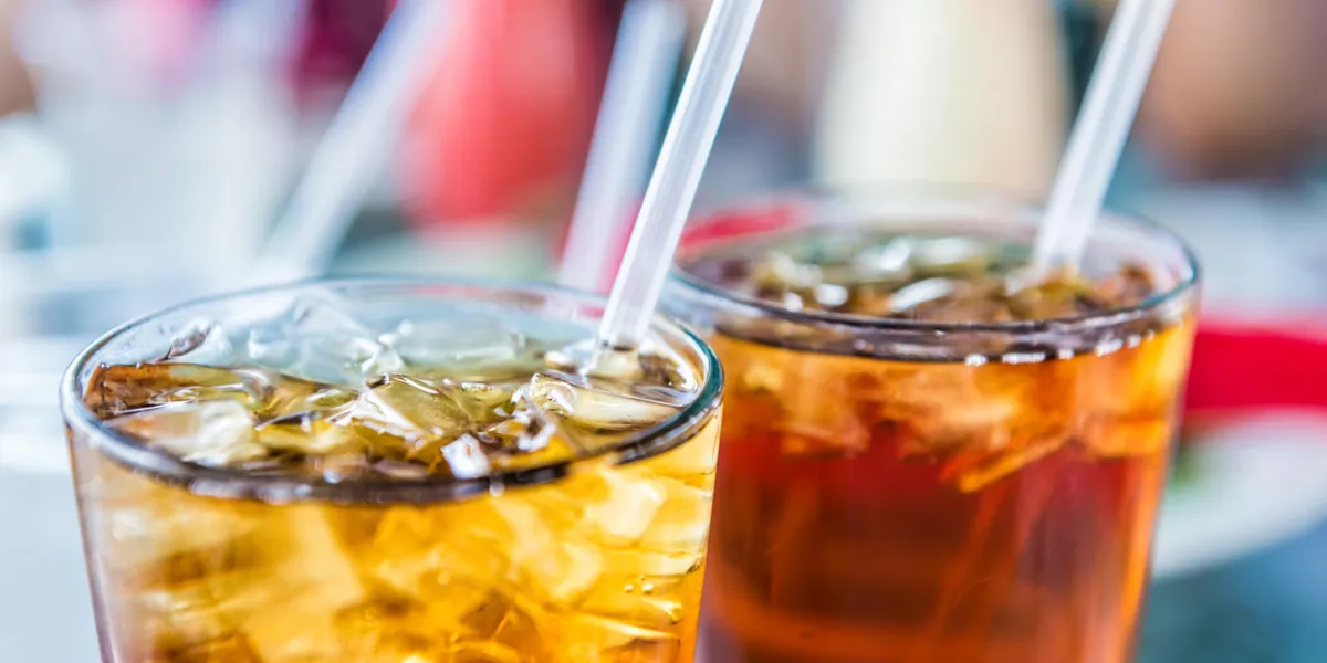 macro closeup of iced tea or soda with ice cubes and straw in glass macro closeup of iced tea or soda with ice cubes and straw in glass