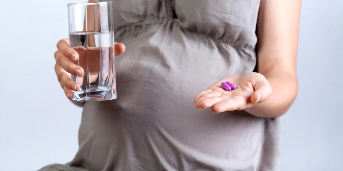 horizontal view of pregnant woman taking medicines