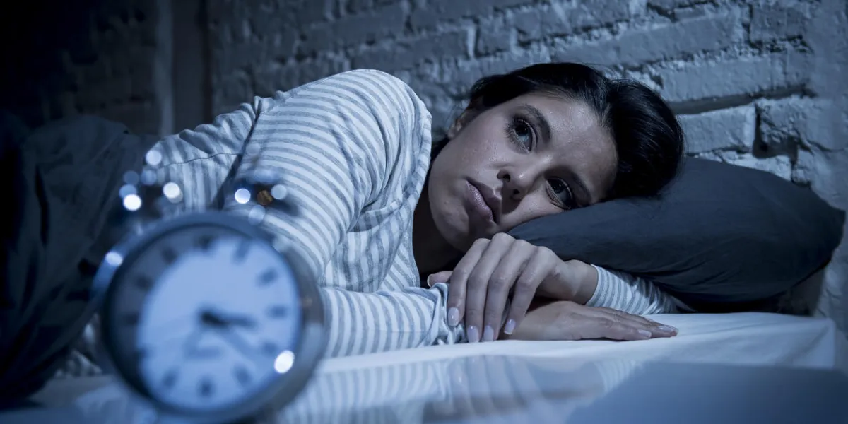 young beautiful hispanic woman at home bedroom lying in bed late at night trying to sleep suffering insomnia sleeping disorder or scared on nightmares looking sad worried and stressed