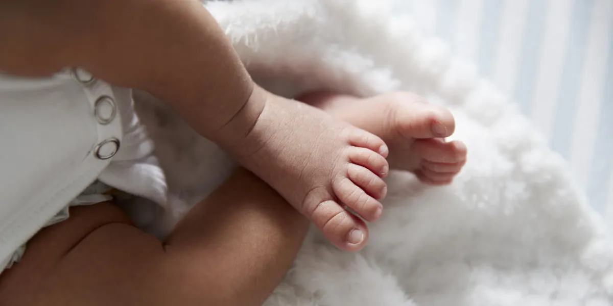 close up of feet of newborn baby in nursery cot close up of feet of newborn baby in nursery cot