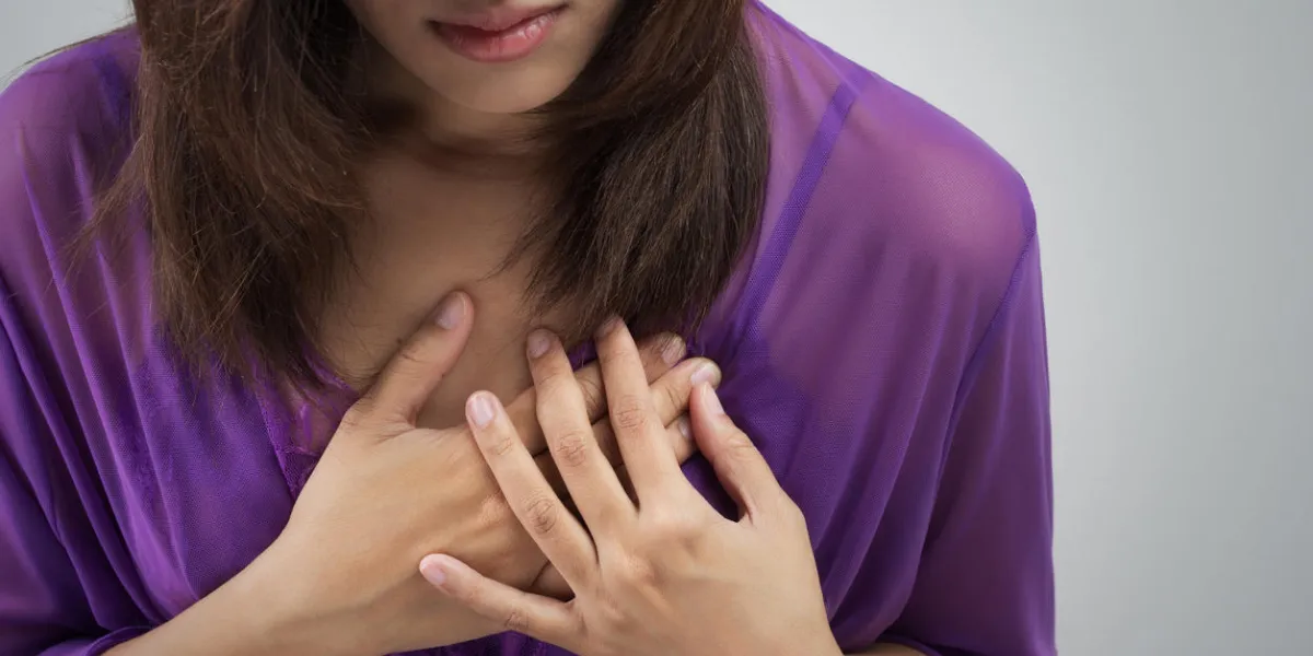 woman holding chest to indicate heart attack