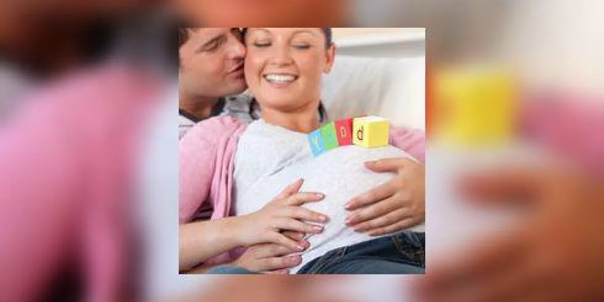 jeune homme embrasser sa femme enceinte avec des lettres de bébé sur le ventre, allongé sur le canapé à la maison jeune homme embrasser sa femme enceinte avec des lettres de bébé sur le ventre, allongé sur le canapé à la maison