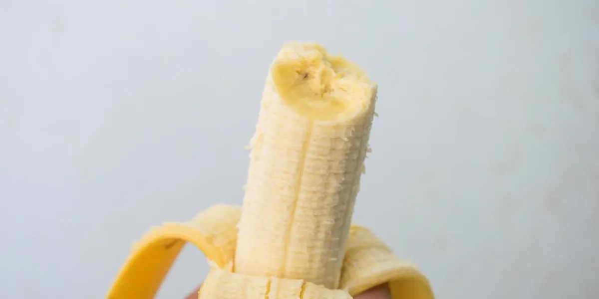 hand holding banana and eating