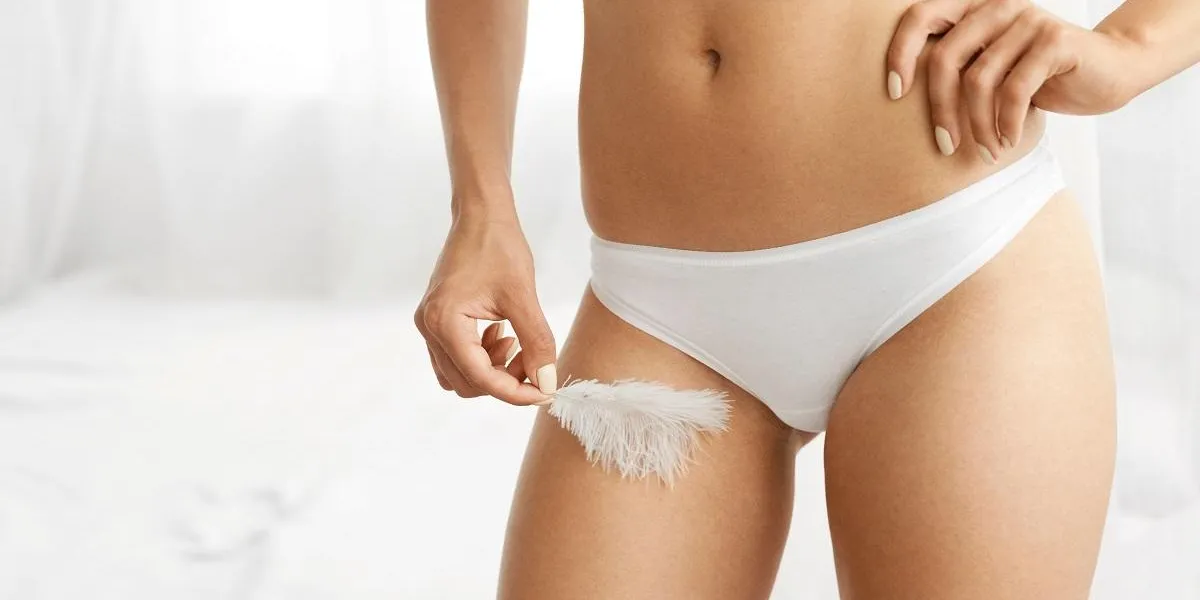 women health and intimate hygiene closeup of beautiful woman's body with smooth soft skin in white bikini panties female hand touching her thigh hip with white feather body care, epilation concepts women health and intimate hygiene closeup of beautiful woman's body with smooth soft skin in white bikini panties female hand touching her thigh hip with white feather body care, epilation concepts