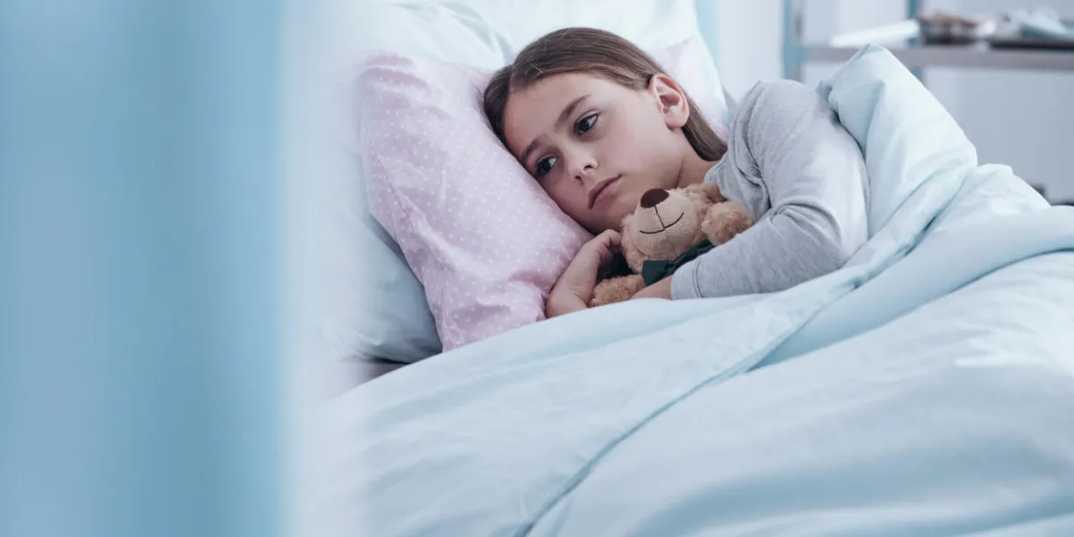 in the background sick sad girl with teddy bear lying in hospital bed in the background sick sad girl with teddy bear lying in hospital bed