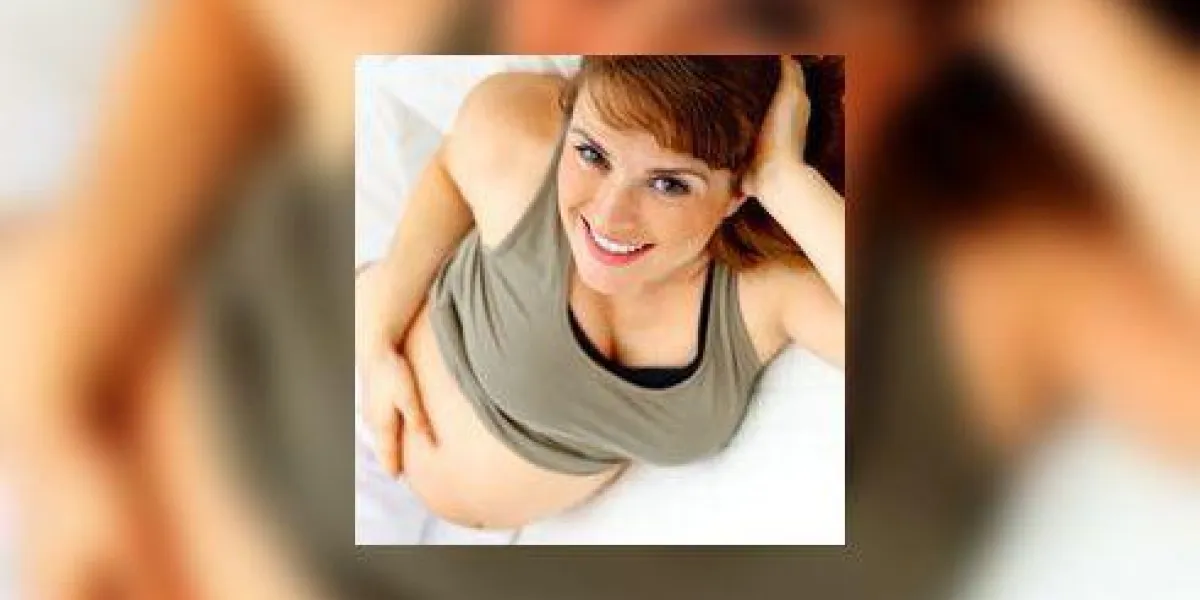 femme enceinte souriante se détendre sur le canapé et tenant son ventre femme enceinte souriante se détendre sur le canapé et tenant son ventre