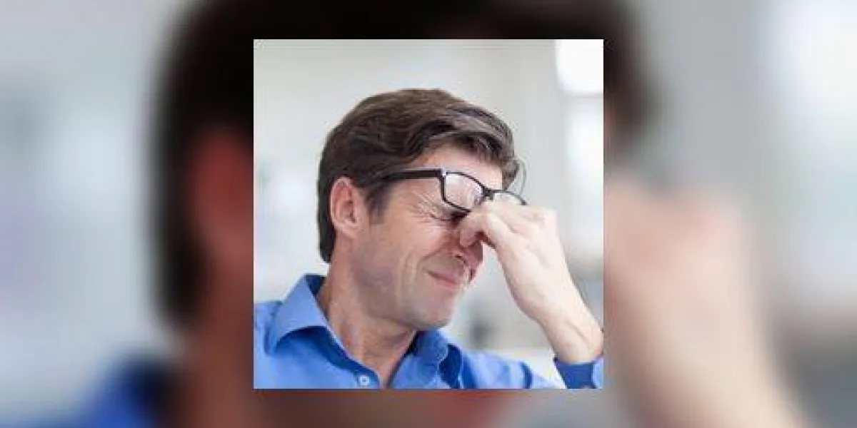 homme mûr grimaçant avec un mal de tête
