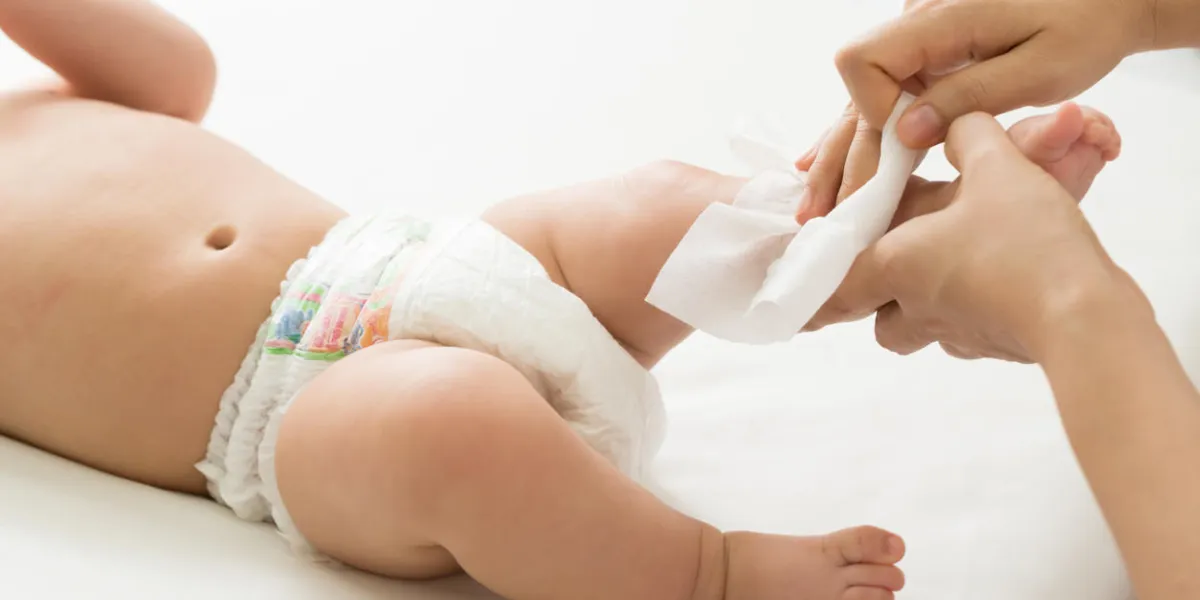 mother cleaning up and wipes body and leg baby by wet tissue