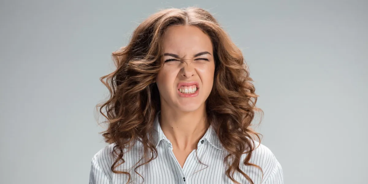 the portrait of disgusted woman on gray