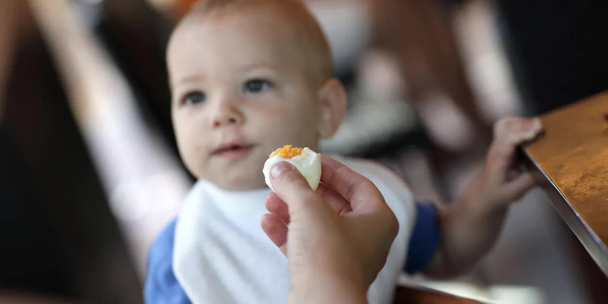 toddler eating boiled egg in the restaurant