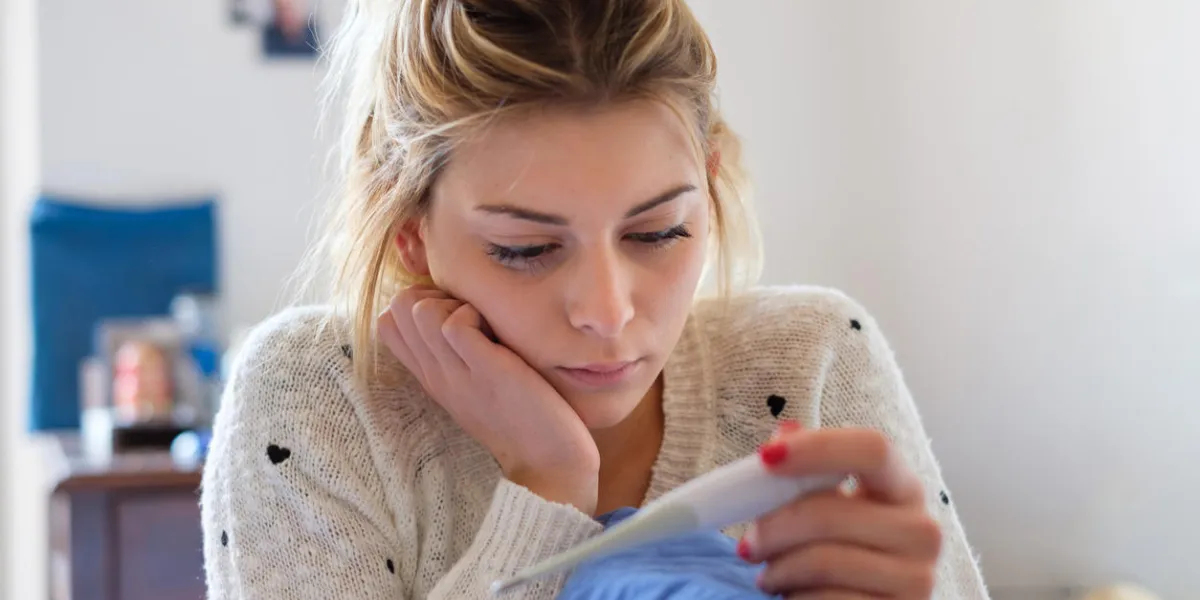 sad young girl reading a pregnancy test result