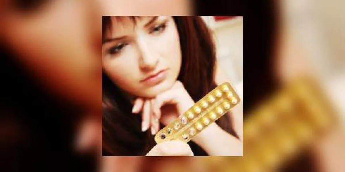 une jolie jeune femme regardant ses pilules contraceptives peu profondes, l'accent est mis sur les pilules