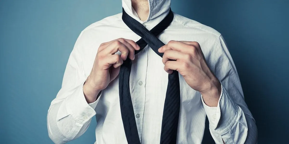 a young man is showing how to tie a necktie