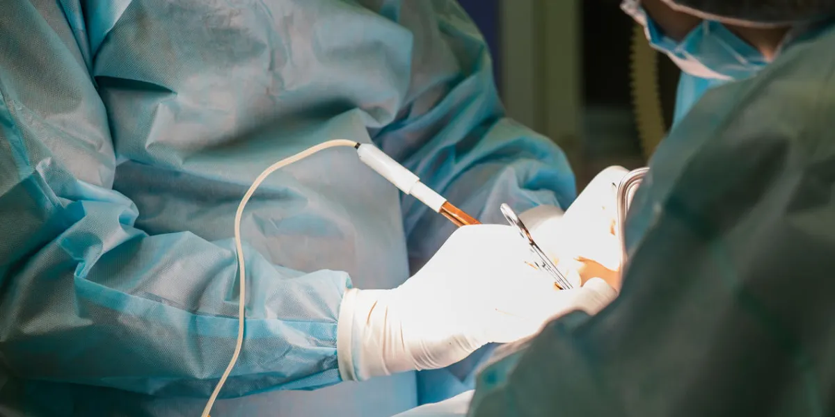 close-up image of sugeon and his assistant performing cosmetic surgery on breasts in hospital operating room doctor holding surgical instrument breast augmentation, enlargement, enhancement close-up image of sugeon and his assistant performing cosmetic surgery on breasts in hospital operating room doctor holding surgical instrument breast augmentation, enlargement, enhancement