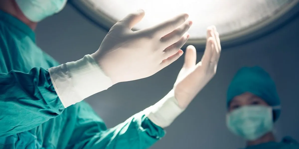 hands in surgical gloves on operation room on background of surgical lamp hands in surgical gloves on operation room on background of surgical lamp